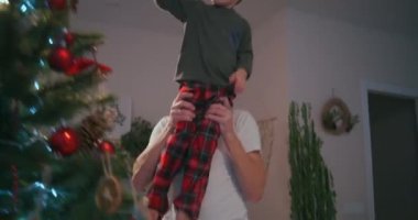 Noel ağacı için son süslemeyi hazırla. Bir çocuk Noel ağacının tepesine bir yıldız yerleştirir.