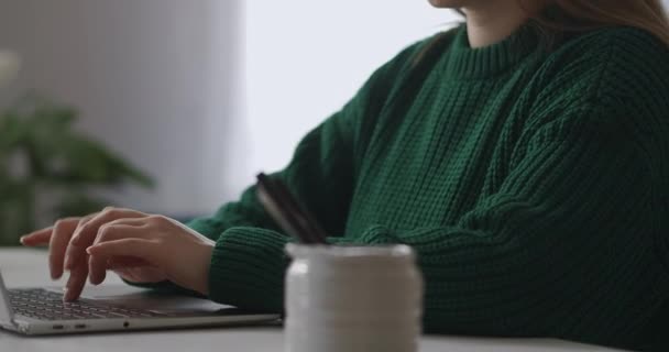 Frilansare kvinna arbetar med bärbar dator i hemmet, närbild av händer på tangentbord och ansikte, skriva meddelanden och skicka — Stockvideo