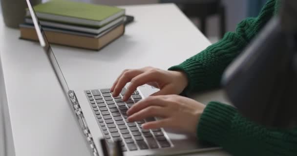 Kvinna kontorsarbetare skriver text på tangentbordet i modern bärbar dator, närbild av händerna på bordet, arbeta med program på internet — Stockvideo