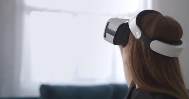 Mujer está utilizando la moderna pantalla HMD, tocando la realidad virtual a mano, retrato de usuario femenino con dispositivo en la cabeza — Vídeo de stock