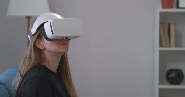 Ritratto di una giovane donna con auricolare VR in casa, display HMD per giocare e per l'istruzione — Video Stock