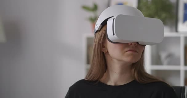 Jovem com novo modelo de exibição montada na cabeça para realidade virtual, retrato médio de mulher com HMD dentro de casa — Vídeo de Stock