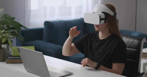 Kadın dizüstü bilgisayara bağlı vr-head ekran kullanıyor, ekranı ve ekranı görüyor, kontrol için elle hareket ettiriyor, orta boy portre — Stok video