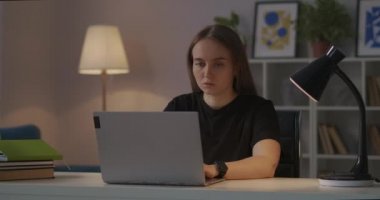 Kadın akşamları evden bilgisayara, internetten serbest çalışmaya, klavyeye metin yazmaya, mesaj ve e-posta göndermeye çalışıyor.