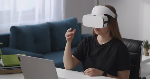 Jovem mulher está vendo por vr fone de ouvido, deslizando e tocando tela virtual, tecnologia moderna de realidade virtual — Vídeo de Stock