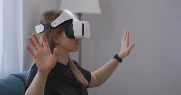 Giovane donna con HMD-display sulla testa sta visualizzando le foto in realtà virtuale, gesticolando le mani per ingrandire l'immagine — Video Stock