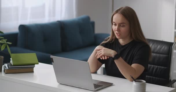 junge Frau kommuniziert per Online-Chat in Laptop, Ferngespräch, redet und gestikuliert, schaut auf Bildschirm
