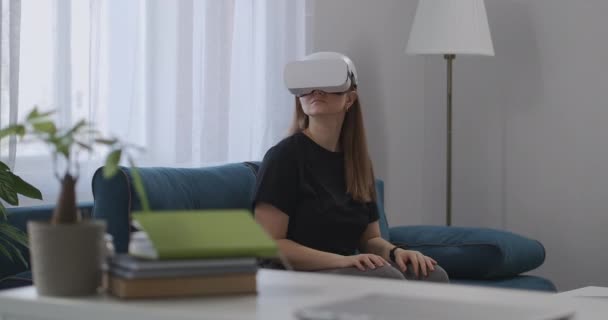Технология виртуальной реальности сегодня, женщина с HMD-дисплеем на голове в квартире, оглядываясь вокруг — стоковое видео