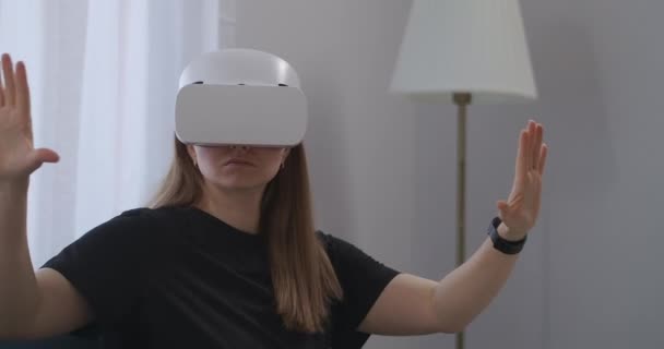 Ung kvinna använder modern teknik av virtuell verklighet, bär VR headset och visa bilder och video — Stockvideo