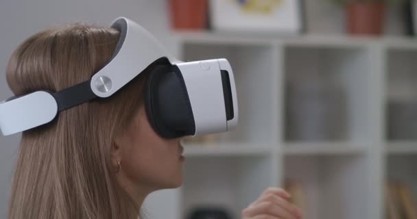 Adolescente femenino está utilizando HMD-pantalla en el hogar, manos móviles para controlar, la tecnología moderna de los videojuegos — Vídeo de stock