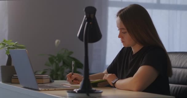 Онлайн образование во время блокировки и самоизоляции при пандемии коронавируса, женщина просматривает удаленную лекцию на дисплее ноутбука — стоковое видео