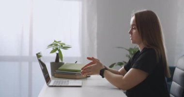 Kadın antrenör online danışmanlık yapıyor, laptop webcam 'e konuşuyor, modern uzmanların izah ve el kol hareketleri, webinar ve konferanslarını anlatıyor