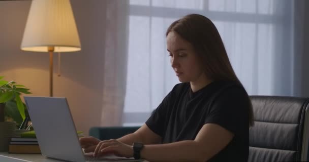 疲倦的女人晚上在办公室用笔记本电脑工作，在键盘上打字，呼吸急促，筋疲力尽，工作过度 — 图库视频影像