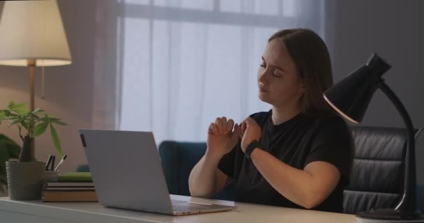 Kvinna känner smärta i nacken under arbetet med laptop på hemmakontoret, osteochondros och över spänningar från datorarbete — Stockvideo