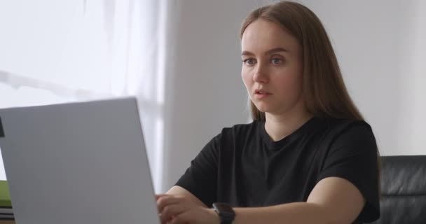 Genç bir kadın internette dizüstü bilgisayarla sörf yapıyor ve sosyal ağlarla iletişim kuruyor. — Stok video