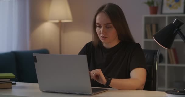 Mulher está trabalhando com laptop em casa, sentindo fadiga e dores na cabeça e pescoço, fechar a capa do notebook e relaxante — Vídeo de Stock