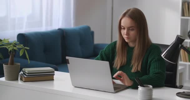 Studentka používá notebook doma pro e-learning, dálkové online vzdělávání, mladá žena pracuje s notebookem — Stock video