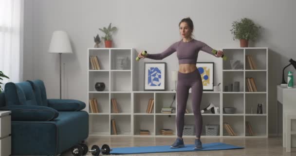 Hermosa mujer está entrenando con pesas en casa, el cuidado de la salud y la buena condición física, tiro de cuerpo entero — Vídeos de Stock