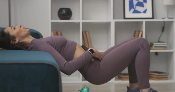 Атлетическая женщина тренируется брюшной полости с весом в гостиной, тренировки в карантине и изоляции в пандемии — стоковое видео