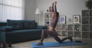 İnce kadın, evde günlük antrenman, osteokondri hastalığı, yoga ve meditasyonu önlemek için vücudunu esnetiyor.