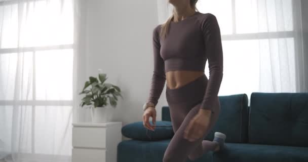 Mladá žena trénuje fitness doma, squatting pro krásné tělo, tělesnou aktivitu a zdravý životní styl, střední střela — Stock video