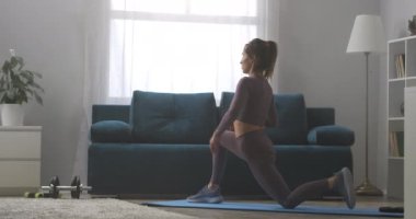 Evde esnemek için jimnastik, kadın kaslarını esnetebilmek için yoga yapıyor.