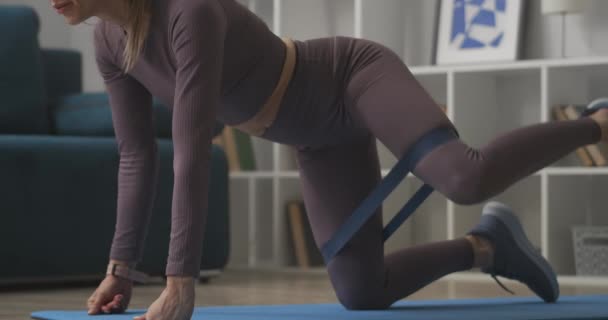 Króliczka siłownia kobiet robi ćwiczenia dla nóg i pośladków z elastyczną opaską fitness, trening domowy dla zdrowego stylu życia — Wideo stockowe