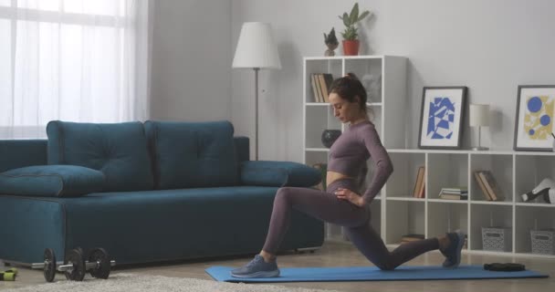 Joven mujer deportiva está haciendo yoga asana, entrenamiento en casa, estirando los músculos de las piernas, estilo de vida saludable — Vídeos de Stock
