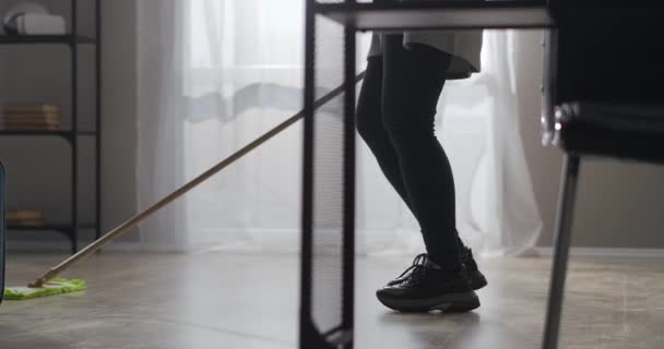 Aufräumen zu Hause an sonnigen Tagen, Nahaufnahme auf den Beinen einer Frau, die sich mit einem Wischmopp wäscht, fröhliches Tanzen — Stockvideo