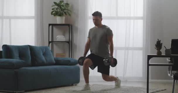 Powerlife делает упражнения с весом, приседая с гантелями в руках, поддерживая форму в изоляции — стоковое видео