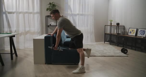 Jock está treinando em casa, levantando haltere por uma mão, treino para bíceps e tríceps, estilo de vida saudável e atividade esportiva — Vídeo de Stock