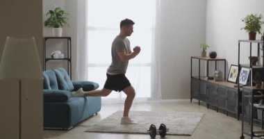 Sporcu apartmanda bacak kasları, oturma odasında ev spor salonu, spor aktiviteleri için fiziksel egzersiz yapıyor.