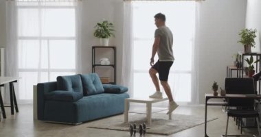 Spor salonlarında spor yapıyor, evde tek başına antrenman yapıyor, mobilyaları spor malzemeleri gibi kullanıyor, bacak kaslarını geriyor.