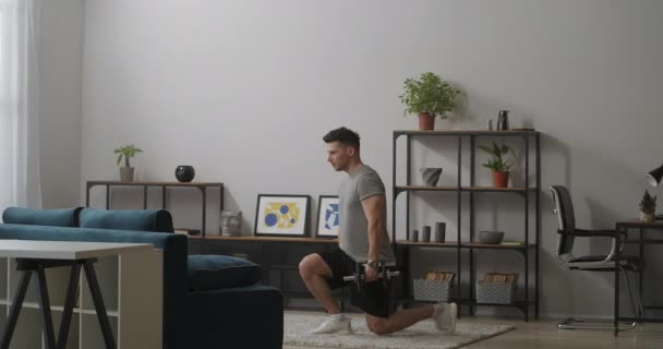 Bodybuilder is squatting with dumbbells in hands, strength training in home gym, keeping fit and healthy lifestyle — Stock Video