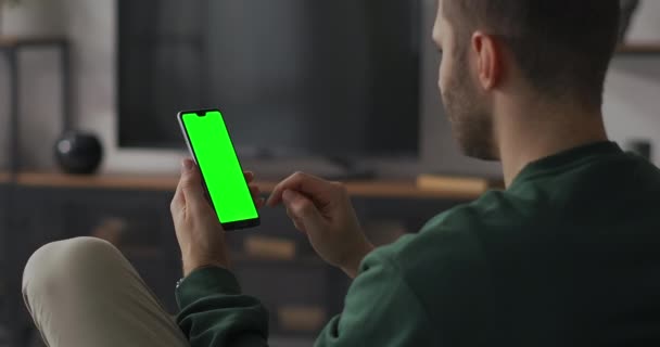 Взрослый мужчина выигрывает в приложении или на сайте нажав кнопку на дисплее смартфона с технологией хромаки — стоковое видео