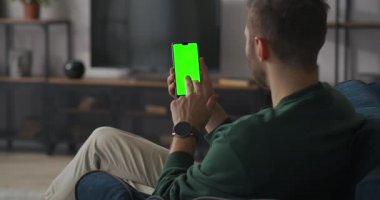 Adam akıllı telefon ekranında e-posta açıyor ve kazanmakla ya da iyi haberle seviniyor, cihazın üzerinde krom anahtar için yeşil ekran