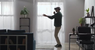 Sanal gerçeklik karaokesi ve video oyunları, yetişkin adam oturma odasında kafasında vr-gözlükle şarkı söylüyor.