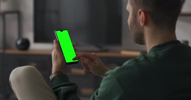 Compras en línea por teléfono inteligente, el hombre está deslizando la pantalla en el sitio web de la tienda en línea, pantalla verde en gadget para componer — Vídeos de Stock
