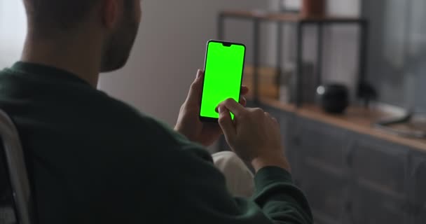 Mens maakt gebruik van nieuwe toepassing op moderne smartphone, vegen touch screen door vingers, chromakey technologie voor het componeren — Stockvideo