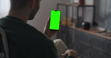 Adam internette akıllı telefondan görüntülü konuşma yapıyor, arkadaşlarına ya da ailesine el sallıyor, yeşil ekran teknolojisi
