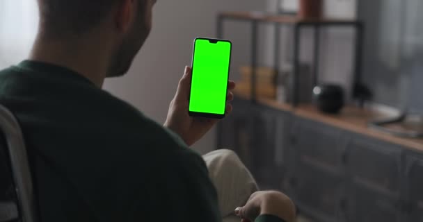 Hombre está charlando en línea por videollamada en el teléfono inteligente, saludando a amigos o familiares, tecnología de pantalla verde — Vídeos de Stock