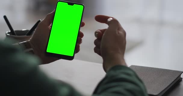 Сучасний смартфон з хроматиєю на екрані в руках чоловічого користувача, сидячи за столом, прочищаючи і натискаючи на сенсорний дисплей, вид крупним планом — стокове відео