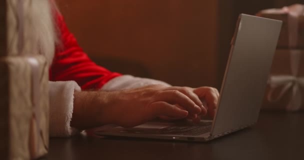 Le Père Noël répond au mail des enfants. Dactylographie sur le clavier de l'ordinateur portable. Les mains du Père Noël ferment. — Video