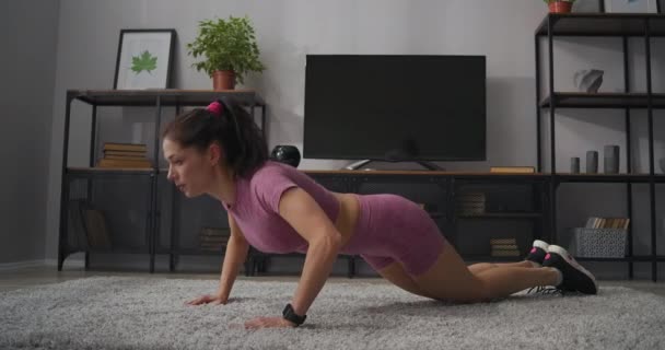 Sexy brunetka lady jest robi pompki w pokój, opierając się na podłodze z dywan, fitness w domu i ćwiczenia fizyczne — Wideo stockowe