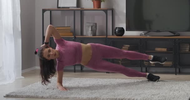 Exercice physique pour les muscles des jambes, jeune femme mince fait de l'exercice dans l'appartement, fitness à la maison pour femme sportive — Video