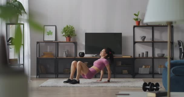 Atletisk dam tränar i lägenhet på helgen, träning för god kroppsform och gå ner i vikt, fullängdare — Stockvideo