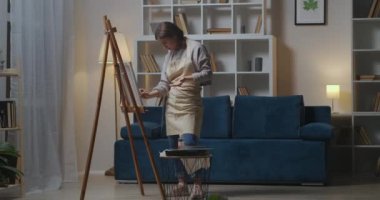 Kadın ressam akşamları resim çiziyor, hobi yapıyor ve hafta sonları en sevdiği hobiyi yapıyor, resim yapıyor.