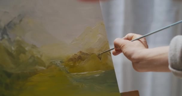 Schilderachtig landschap door olieverf op doek, vrouwelijke kunstenaar tekent details op foto, close-up zicht van de hand met penseel — Stockvideo