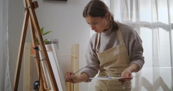 Portré tehetséges nő rajz festék a nappaliban, otthon dolgozó stúdió, közepes portré lövés, töltés időt hétvégén — Stock videók
