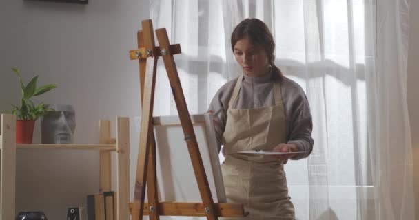 Jovem artista estudante mulher está desenhando na sala de estar, espaço artístico para pessoa criativa, usando pincel e corantes — Vídeo de Stock